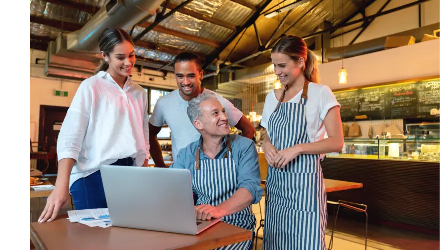 Restaurant staff reviewing schedules on a laptop